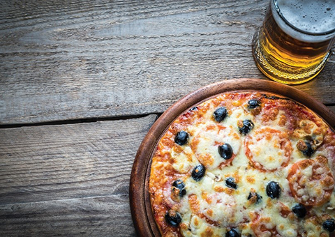 A pizza and beer on a wooden table